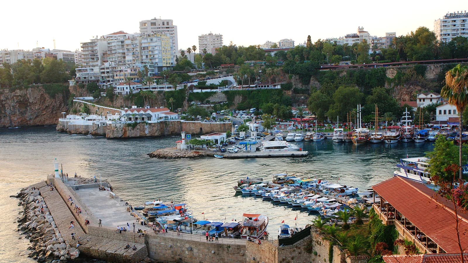 Portul vechi din Antalya, ambarcațiuni și falezele orașului la apus